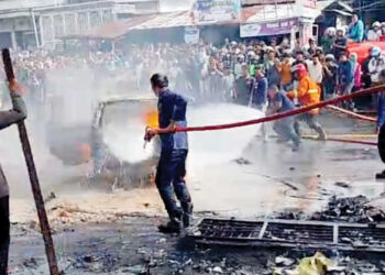 PADAMKAN API— Petugas Damkar berusaha memadamkan api yang membakar satu unit mobil Avanza usai mengisi BBM di SPBU Garegeh, Senin (15/12) sore.