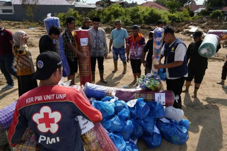 BERJIBAKU— Mahasiswa UNP ikut menjadi relawan berjibaku membantu korban bencana banjir bandang