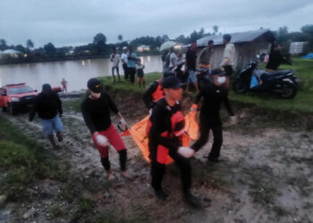 EVAKUASI— Tim SAR mengevakuasi korban terseret arus Batang Anai yang ditemukan Minggu (14/12).