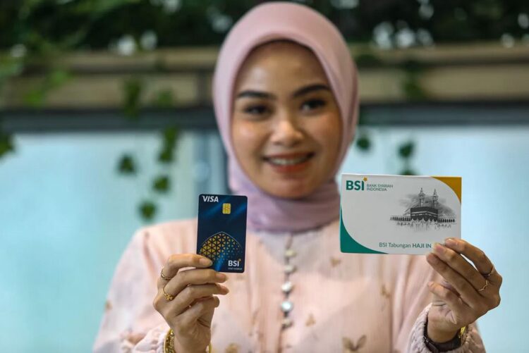 PELUNCURAN— Karyawan menunjukkan buku tabungan dan kartu ATM tabungan Haji BSI saat peluncuran di Kantor Pusat BSI Jakarta.