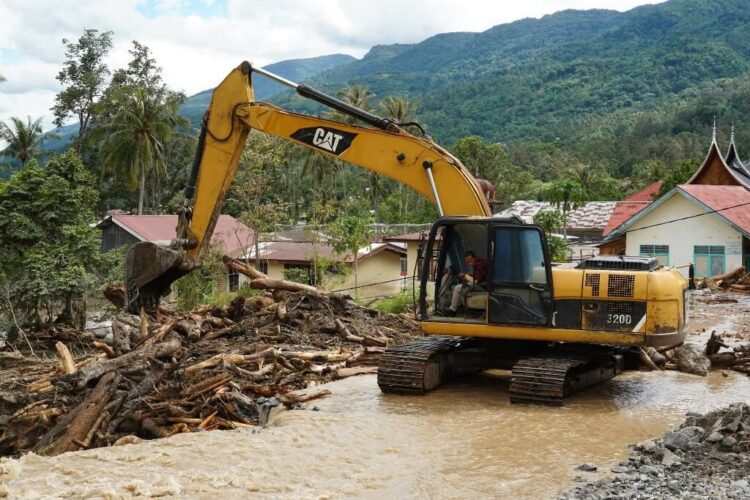 PEMBERSIHAN— Alat berat sedang melakukan pembersihan material banjir bandang di Kecamatan Batipuh Selatan, Kabupaten Tanahdatar.