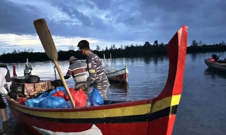 NAIK PERAHU—Terlihat prajurit Kodaeral II naik perahu boat menyalurkan bantuan ke daerah terisolir.