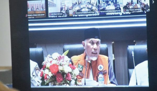 RAPAT VIRTUAL— Bupati Agam Benni Warlis mengikuti rapat evaluasi tanggap darurat bencana banjir bandang dan tanah longsor di wilayah Provinsi Sumatera Barat yang digelar secara virtual dari Pos Komando Tanggap Darurat Kabupaten Agam, Senin (22/12).