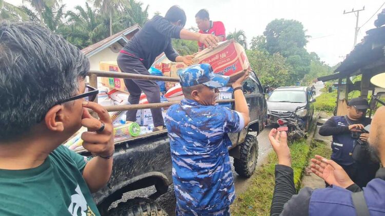 SALURKAN—Terlihat prajurut TNI AU sedang menyalurkan bantuan pada warga yang terdampak bencana.