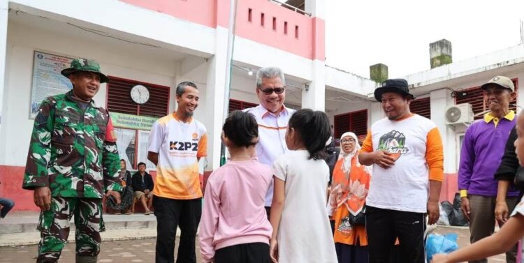BERBINCANG—Ketua DPRD Sumbar, Muhidi saat berbincang dengan anak-anak korban banjir bandang yang mengungsi di SDN 02 Cupak Tangah.