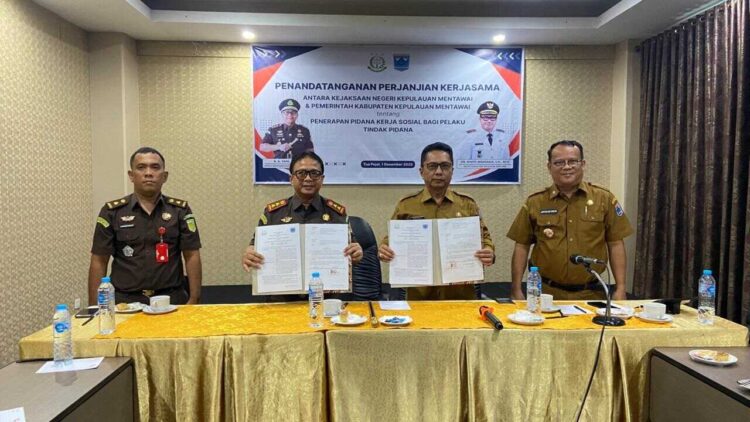 LIHATKAN—Kepala Kejaksaan Negeri Kepulauan Mentawai, R.A. Yani, S.H, dan Bupati Kabupaten Kepulauan Mentawai yang diwakili oleh Martinus Dahlan lihatkan MoU.