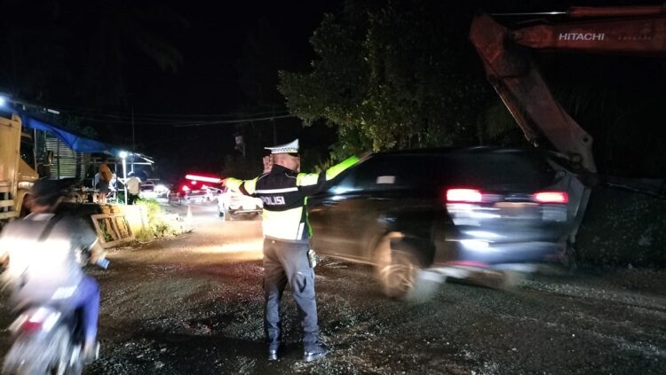ATUR LALIN—Jajaran Polsek Pangkalan Polres 50 Kota saat  melaksanakan pengaturan arus lalu lintas (Lalin) di lokasi jalan amblas pada ruas Jalan Lintas Sumatera Barat–Riau.