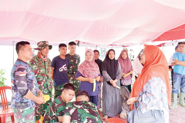 BANTUAN LOGISTIK— Ketua Tim Penggerak PKK Kabupaten Agam, Ny. Merry, menyalurkan bantuan logistik ke sejumlah dapur umum yang berada di Jorong Salareh Aia Utara dan Salareh Aia Timur, Minggu (21/12).