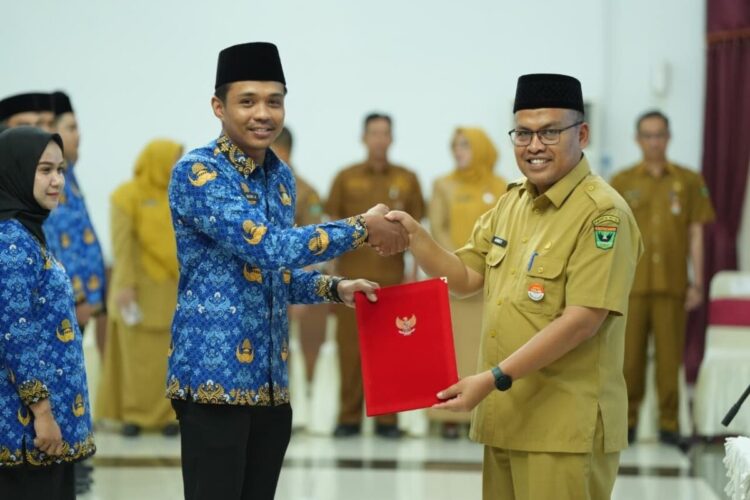 SERAHKAN SK— Sekretaris Daerah Provinsi Sumatera Barat, Arry Yuswandi menyerahkan Surat Keputusan (SK) pengangkatan kepada 117 tenaga honorer Pemerintah Provinsi Sumatera Barat, Senin (29/12).