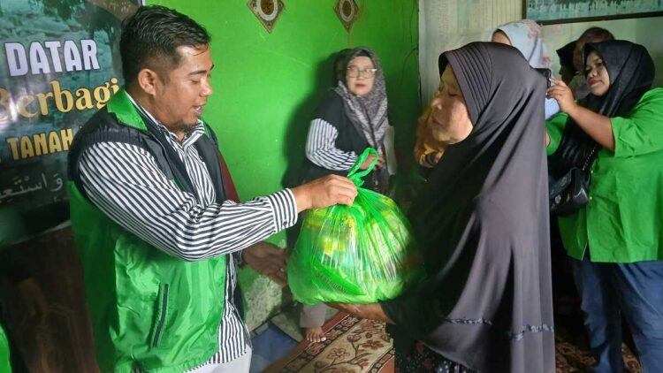 SERAHKAN—Sekretaris DPC PPP Rahmad Dani saat menyerahkan bantuan pada korban bencana.