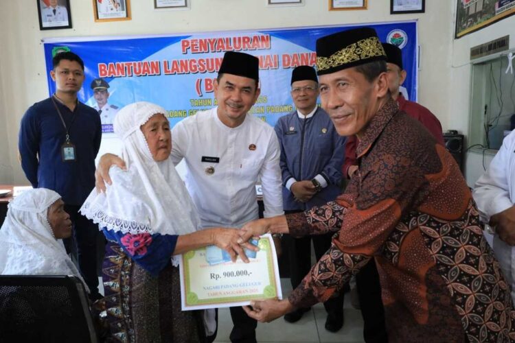 SERAHKAN BLT— Wakil Bupati Pasaman Parulian, menyerahkan Bantuan Langsung Tunai (BLT) Dana Desa Triwulan IV kepada lansia.