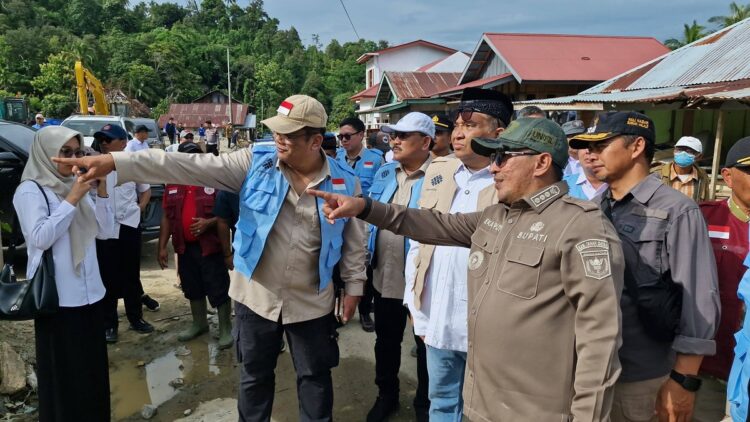 KUNJUNGI LOKASI BANJIR— Wakil Menteri Ketenagakerjaan (Wamenaker) Afriansyah Noor Dt. Rajo Basa didampingi Bupati Tanah Datar Eka Putra, saat mengunjungi korban bancana banjir bandang di jorong Muaro Ambius Guguak Malalo, Rabu (24/12).