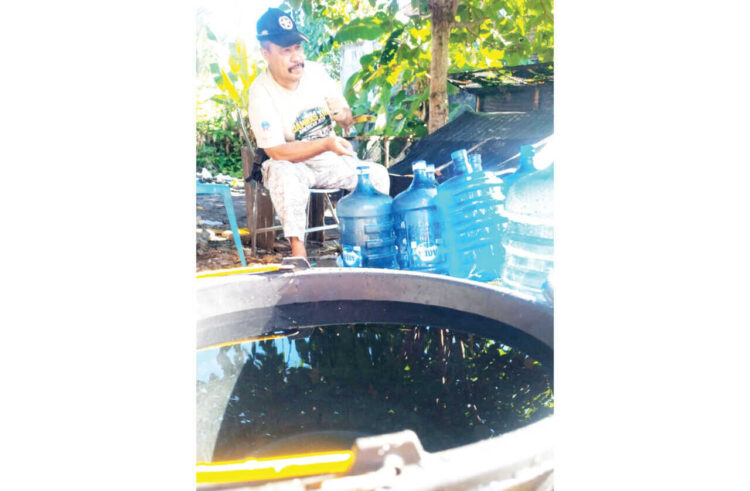 PENGISIAN AIR BERSIH— Afdal, melayani pengisian air bersih untuk warga.