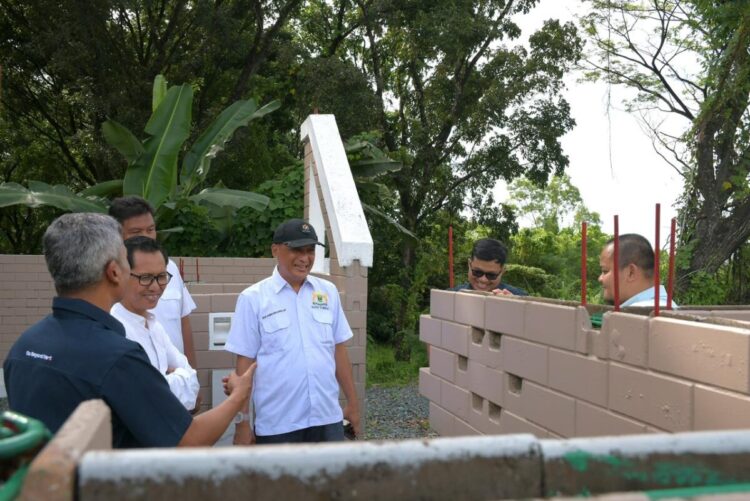 KUNJUNGI RUMAH CONTOH— Ketua Kadinb Sumbar Buchari Bachter, bersama Kepala Dinas Perumahan Rakyat dan Kawasan Permukiman (DPRKP) Kota Padang Raf Indria, mengunjungi rumah contoh Semen Padang Bata Interlock (SEPABLOCK) di Indarung, Rabu (24/12).