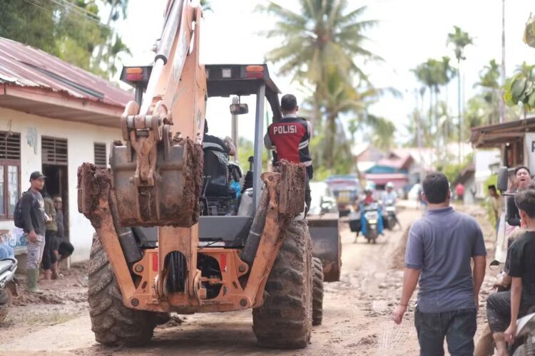 BERSIHKAN LUMPUR—Terlihat alat berat saat bekerja bersihkan lumpouir di jalan dan rumah warga.