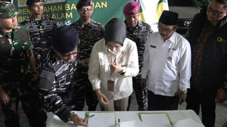 PENYERAHAN BANTUAN— Kepala Badan Penyuluhan dan Pengembangan Sumber Daya Manusia Pertanian (BPPSDMP) Kementerian Pertanian, Dr. Idha Widi Arsanti, didampingi Dankodaeral II Laksamana Muda Sarimpunan Tanjung teken berkas penyerahan bantuan di atas KRI Makasar, Jumat (19/12)