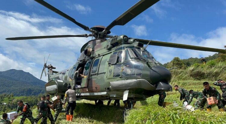 TEMBUS LERENG BUKIT— Helikopter Caracal EC-725/H225M TNI AU tail number HT-7206 dengan Pilot Kapten Pnb Indra Sakti dan Lettu Pnb Galang Dirgantara dari skadron 8, tembus lereng bukit Nagari Sungai Limau bersama Prajurit  TNI Angkatan Udara mendistribusikan bantuan korban bencana, Jumat (19/12).