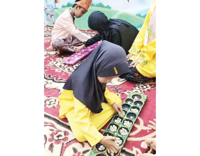 PERMAINAN TRADISIONAL— Sejumlah anak memainkan permainan congklak saat kegiatan Festival Permainan Tradisional Anak yang digelar Kecamatan Lubeg di Kampung Seni Palapa, Kelurahan Parak Laweh Pulau Aia Nan XX, Kamis (25/12).