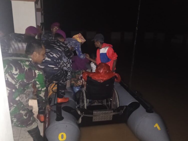 EVAKUASI—Terlihat prajurit Yonmarhanlan II sedang berjibaku evakuasi wargha yang terjebak banjir dengan perahu karet.