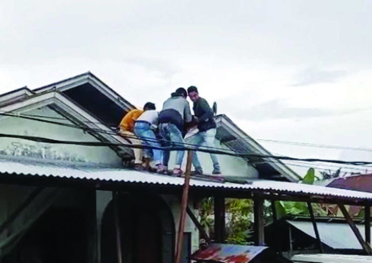 Perbaiki Talang Air di Atap Rumah, Pekerja Bangunan Tewas Tersengat Listrik 1 EVAKUASI KORBAN— Warga menurunkan korban yang tersetrum di atap rumahnya, Sabtu (13/12) siang