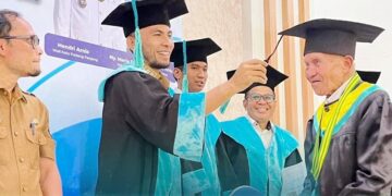 WISUDA LANSIA— Wakil Wali Kota Allex Saputra melakukan proses pemindahan toga saat Wisuda Sekolah Lansia Tahun 2025 bagi 64 peserta dari Kecamatan Padang Panjang Timur (PPT) di Aula Kantor Camat, Senin (29/12).