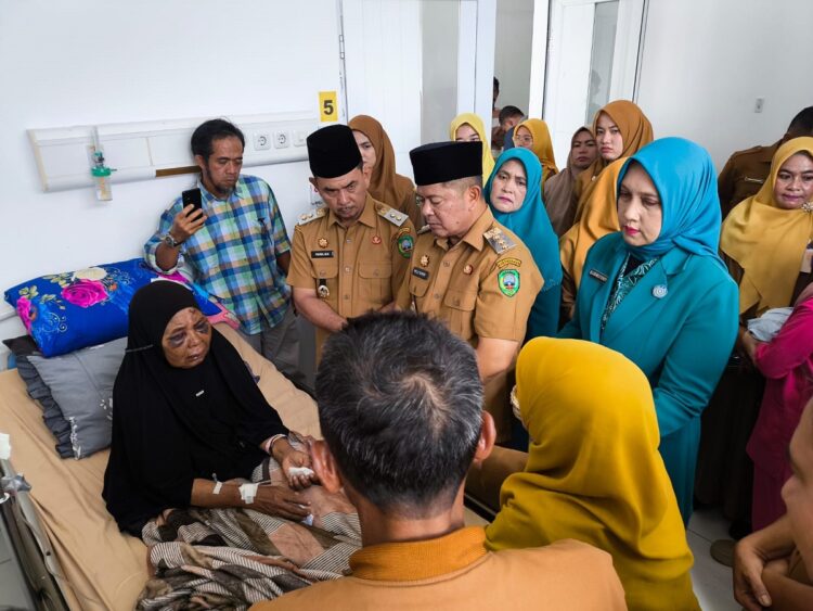 KUNJUNGI KORBAN PENGANIAYAAN— Bupati Pasaman Welly Suhery, didampingi Wakil Bupati Pasaman Parulian, berdialog dengan  Saudah, warga yang tengah menjalani perawatan medis akibat dugaan penganiayaan di wilayah Rao.