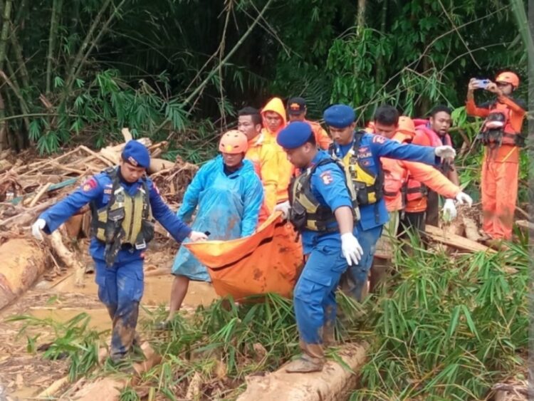 EVAKUASI— Petugas gabungan mengevakuasi jenazah korban bencana Sumatra.
