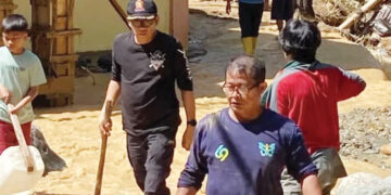MEMBERSIHKAN—Wakil Ketua DPRD Sumbar, Evi Yandri turun langsung membersihkan rumah warga yang terdampak banjir di Kota Padang.