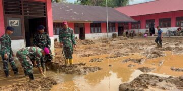BERSIHKAN SEKOLAH— Prajurit Korps Marinir sedang membersihkan lumpur di SDN No. 152981 Tukka 1B, Jalan Humala Tambunan, di Takka, Tapanuli Tengah, sebelumnya  kantor camat juga dibersihkan.