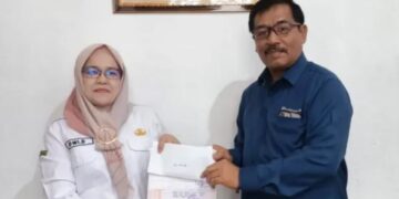 IURAN JAMINAN SOSIAL— General Manager PTBA-UPO Yulfaizon memberikan bantuan iuran jaminan sosial buat pekerja rentan kepada Kepala Dinas PM PTSP Naker Sawahlunto Dwi Darmawati