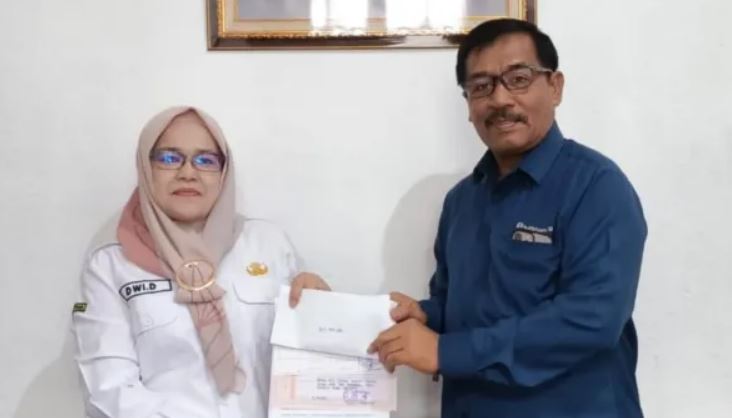 IURAN JAMINAN SOSIAL— General Manager PTBA-UPO Yulfaizon memberikan bantuan iuran jaminan sosial buat pekerja rentan kepada Kepala Dinas PM PTSP Naker Sawahlunto Dwi Darmawati