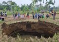 TANAH BERLUBANG— Warga Jorong Tepi, Nagari Situjuah Batua, Kabupaten Limapuluh Kota, mengerumuni  lokasi tanah berlubang (Sinkhole), Minggu (4/1). Fenomena alam yang oleh penduduk lokal disebut sebagai “sawah luluih” ini terjadi di sawah yang digarap Adrolmios alias Si Ad, (61), warga Nagari Situjuah.